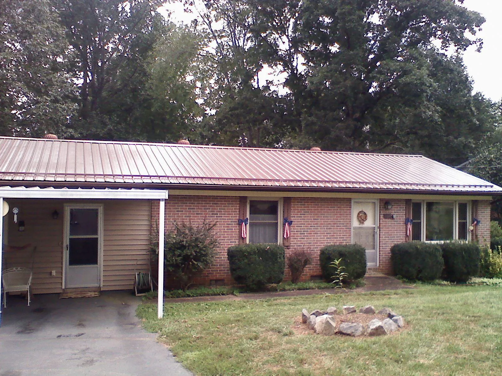 Bronze metal roof and carport on a brick ranch home — Roof Repair work by our crew in Atkinson