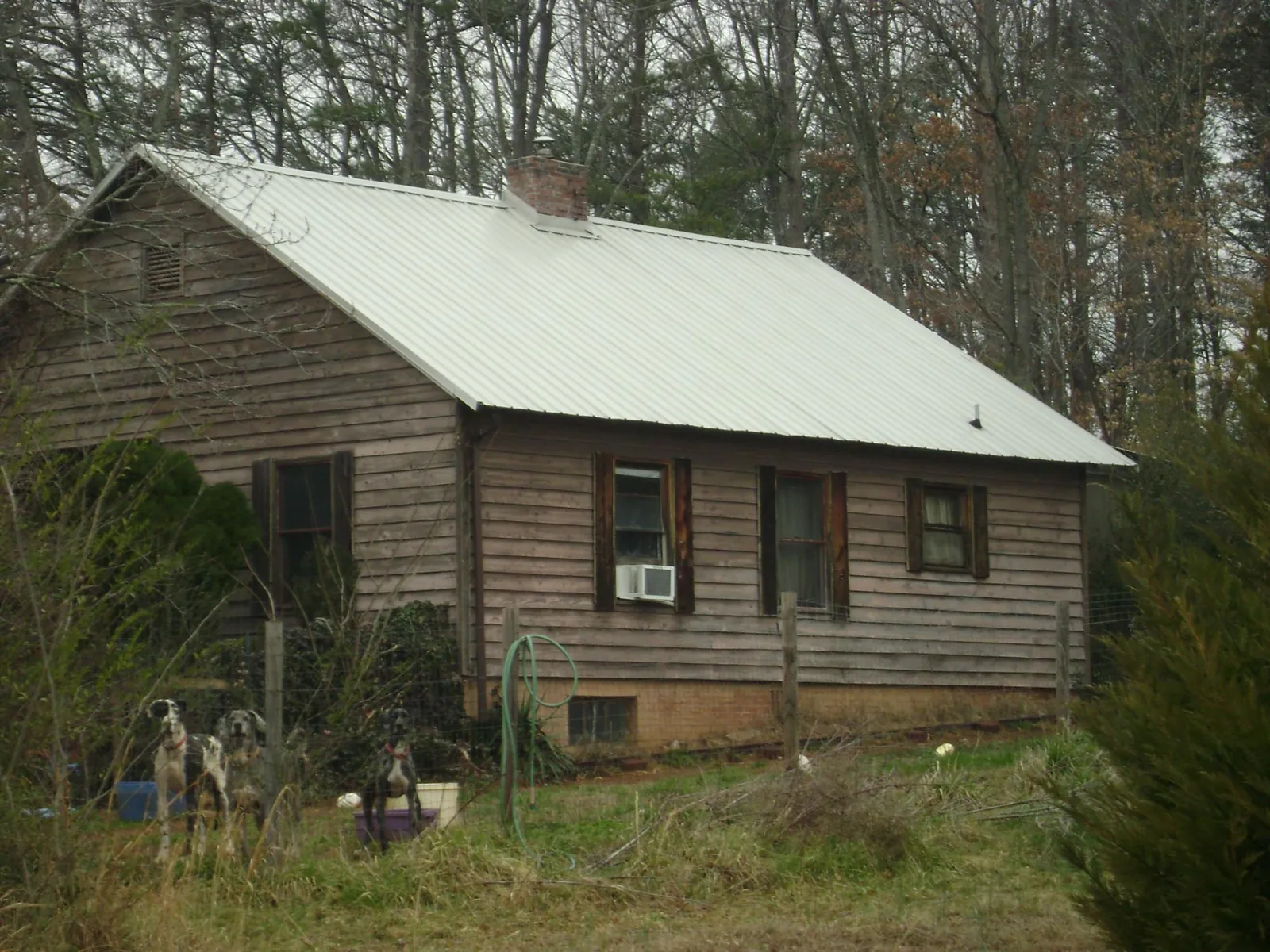 White metal roof on an old wood sided farmhouse, from a Metal Roof Installation job in Atkinson